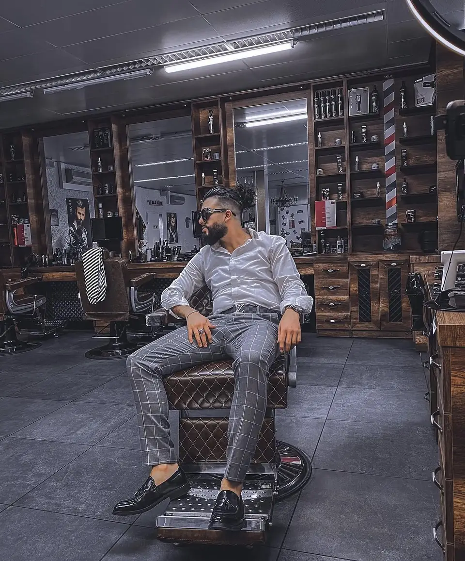Mazin, barbier de Maz Barber, assis dans un fauteuil de barbier